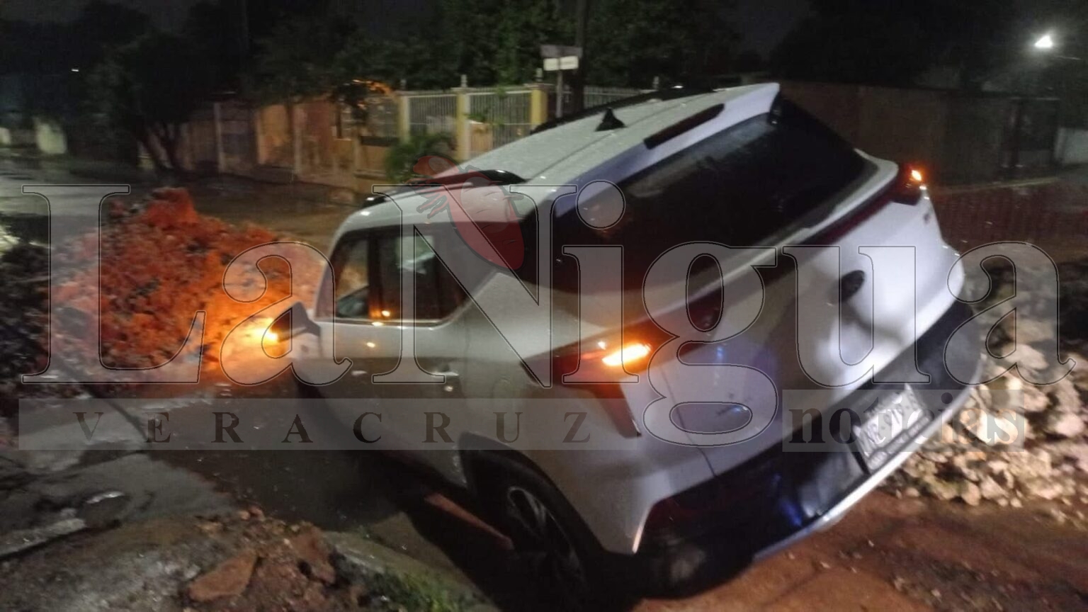 Conductora cae con su vehículo en obra sin señalizar durante tormenta en Minatitlán.