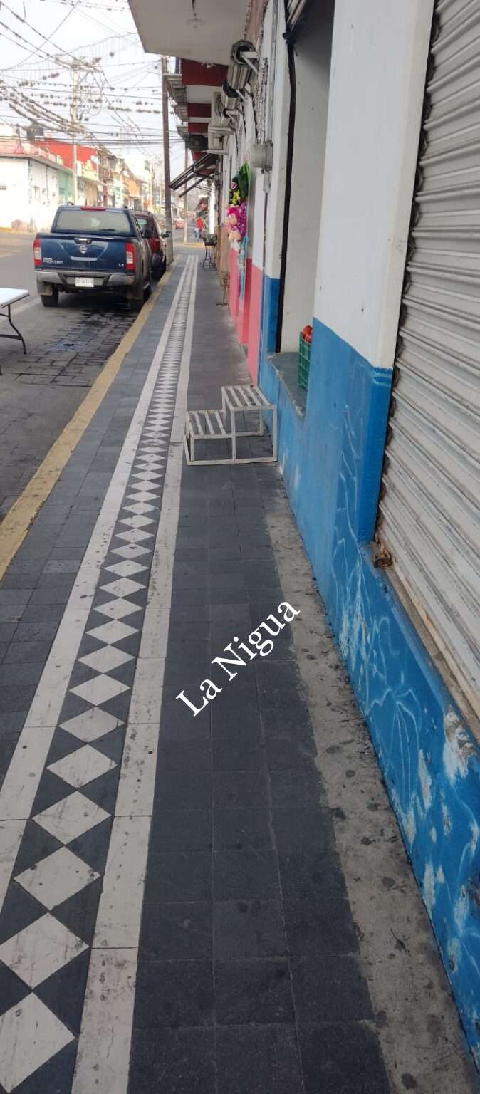 Escalera obstruye paso en banqueta