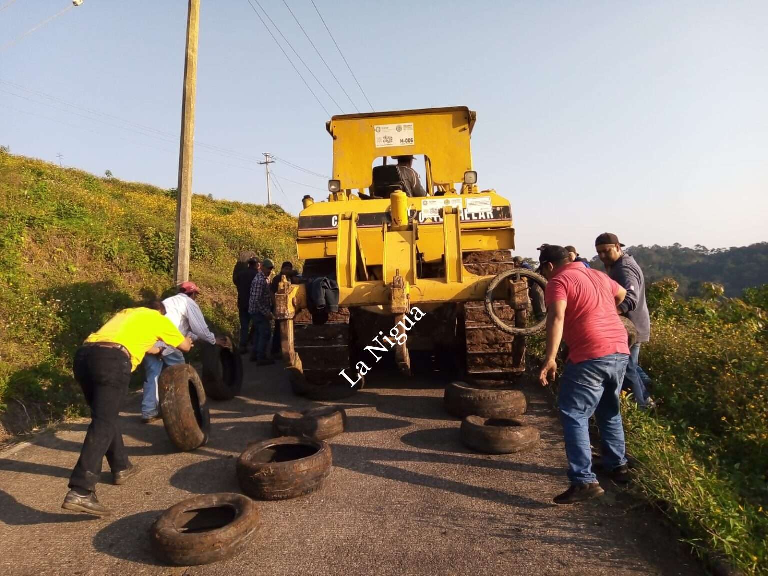 Trabajan campesinos en abrir camino cosechero.