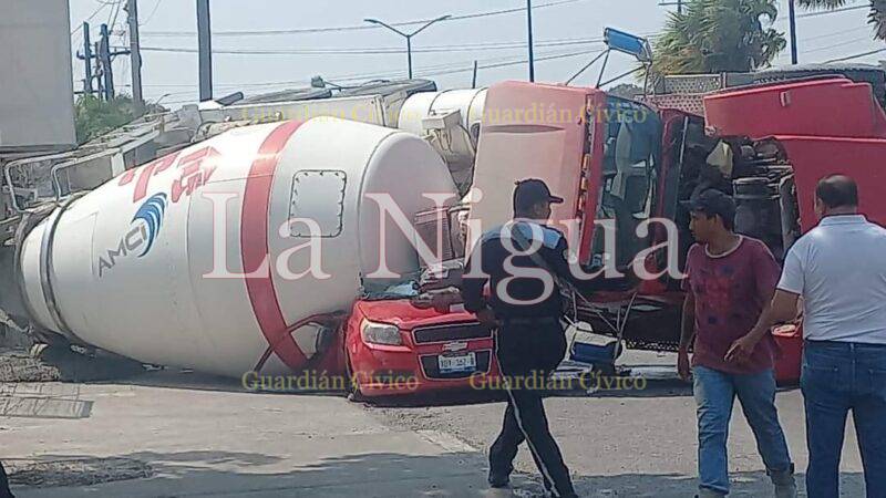Revolvedora cargada de cemento cae sobre vehículo compacto
